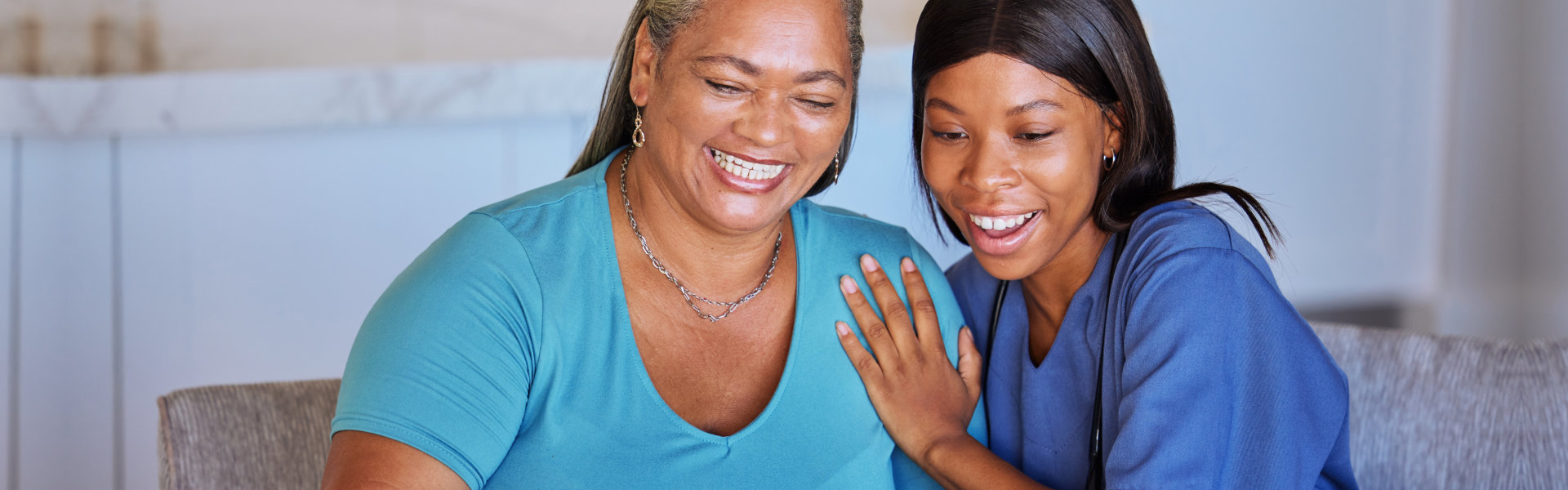 caregiver woman laughing with senior woman